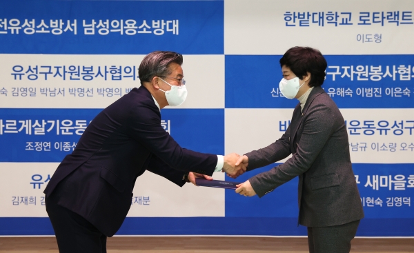 17일 유성종합스포츠센터에서 열린 코로나19 예방접종 유공자 표창 수여식에서 정용래 유성구청장(왼쪽)이 유공자에게 표창패를 수여하고 있다