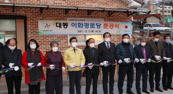 이화경로당 준공식 참여자들이 테이프 커팅을 하고 있다