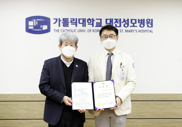 가톨릭대학교 대전성모병원 김용남 병원장과 산부인과 정인철 교수가 장애인 건강수준 향상에 기여한 공로로 받은 대전시장 표창장을 들고 기념촬영