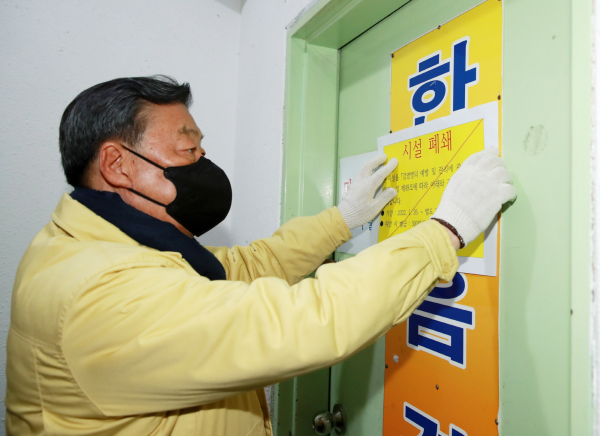 지난 26일 집단감염이 발생한 태안읍의 한 경로당에 시설폐쇄 스티커를 부착 중인 가세로 군수.