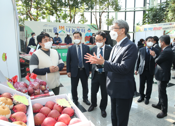 27일 대전시 본사에서 댐주변지역 사과 농가와 함께 ‘제1회 물벗 나눔장터, 댐주변지역 사과 팝업 스토어‘ 행사를 열었다. 한국수자원공사 박재현 사장(사진 앞 가운데)이 이날 행사에 참여한 지역 농민에게 제품 설명을 듣고 있다.