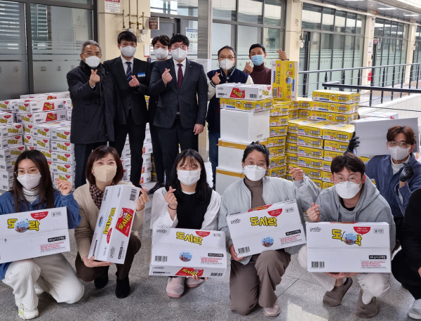 목원대 기숙사에서 천성교회 관계자들이 간편식을 전달하며 기념촬영을 하고 있다.