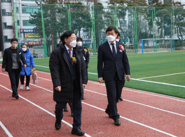 설동호 대전광역시교육감을 비롯한 관계자들이 친환경운동장을 둘러보며 학교장의 설명을 듣고 있다