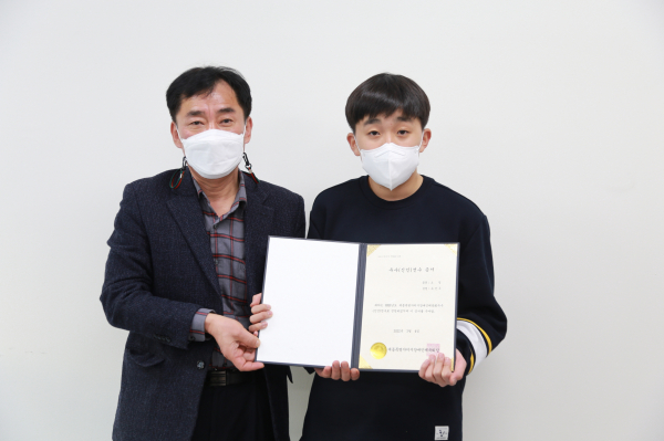 세종시장애인체육회 관계자가 신인선수로 선발된 유건우 선수(사진 오른쪽·조정)에게 우수선수 증서를 전달하고 있다.