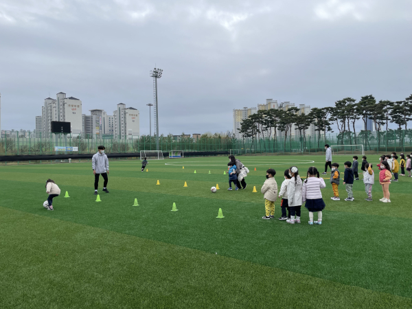 무료축구교실을 열고 어린이들에게 축구를 가르치고 있는 장면