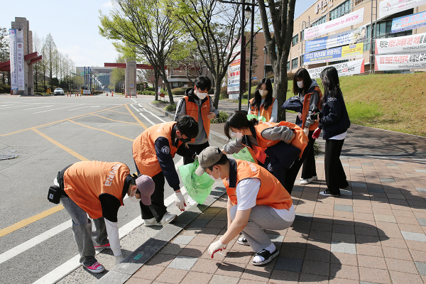 목원대 사회과학대학 학생들이 대학 주변 상가에서 쓰레기를 줍는 봉사활동을 벌이고 있다.