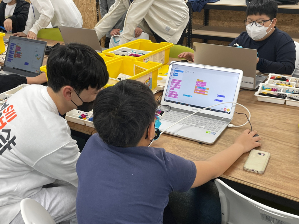 호서SW교육봉사단원이 참여 학생의 스크래치 코딩을 도와주고 있다.