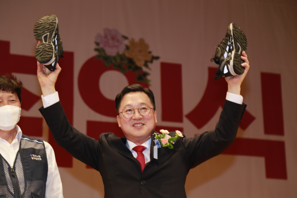 이장우 대전시장이 1일 취임식에서 시청 공무원 노조로부터 운동화를 선물받은 뒤 두 팔을 번쩍 들어올리고 있다. 노조 측은 이 시장에게 열심히 뛰어달라는 의미로 운동화 한 켤레를 선물했다.