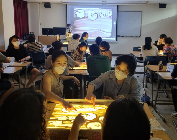 문화콘텐츠대학 강의실에서 진로진학상담교사들이 샌드아트 체험을 하고 있다