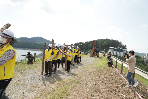 유관기관과 공사 직원들이 저수지 사면 유실 긴급복구를 준비하는 모습