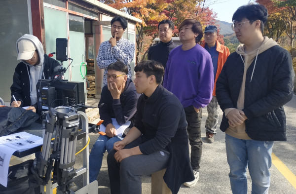 영화 ‘좀비는 좀비끼리 우리는 우리끼리’ 촬영장에서 오세섭 교수(앞줄 왼쪽 두 번째)와 배우, 스태프 등이 촬영된 영상을 살펴보고 있다.