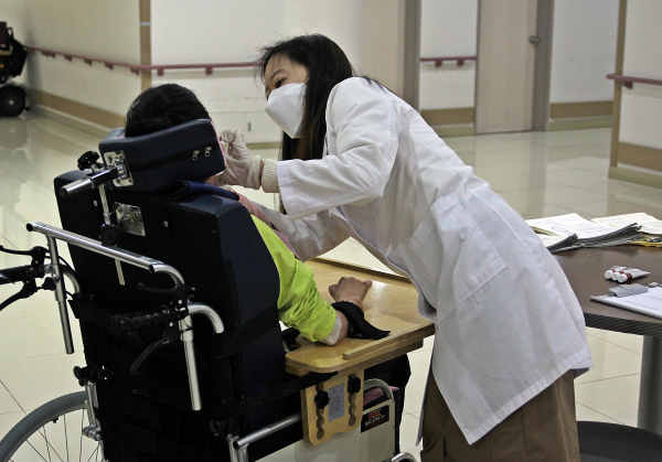 치과 이경은 교수가 성모의 마을 입소자를 대상으로 구강검진을 실시하고 있는 모습.