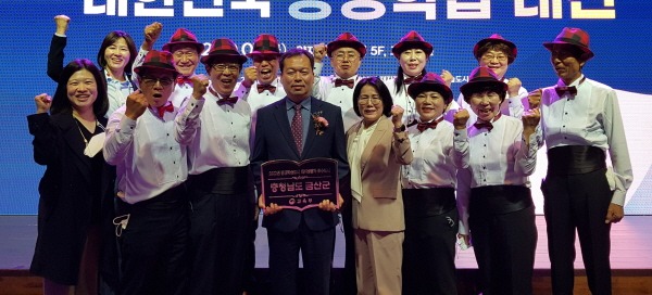 이종규 금산부군수(앞열 왼쪽 네 번째)와 금산군 색소폰 동아리 회원들이 평생학습도시 우수도시 동판을 들고 기념사진을 찍고 있다.