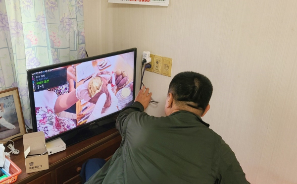 지난 21일 송암2리 주민이 이웃 가정에 스마트 돌봄 플러그를 설치하는 모습.