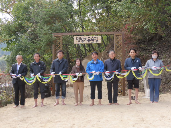 김종연(우측 네 번째) 국립산림치유원장이 25일 산림치유원 맨발치유숲길에서 열린 조성기념식에서 맨발 걷기 행사에 앞서 박동창(우측 세 번째) 맨발걷기시민운동본부 회장 등 참석 내빈들과 테이프 커팅을 하고 있다.