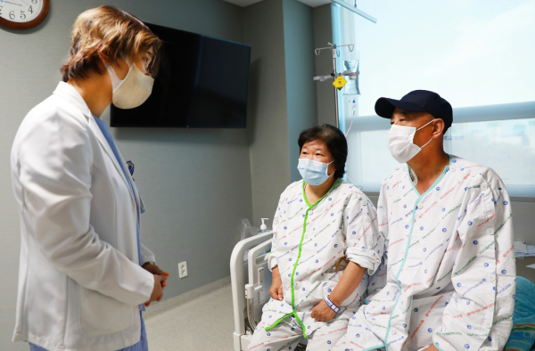 외과 김송이 교수가 생체 신장이식 수술 후 회복 중인 부부에게 몸 상태를 확인하며 주의사항을 설명하고 있다.