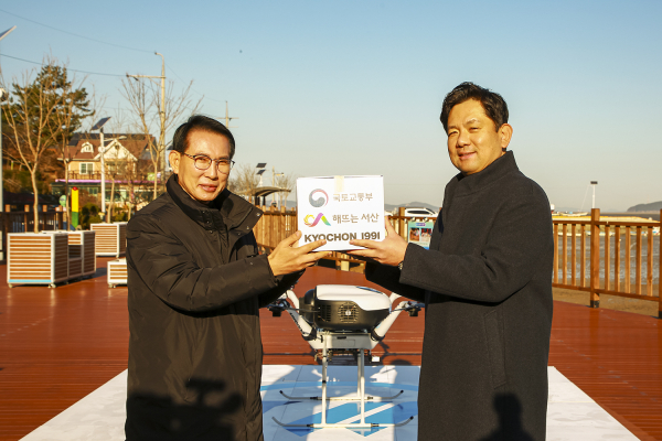 8일 지곡면 중왕리 중리포구에서 열린 치킨 드론배송 시연회에서 이완섭 서산시장과 윤진호 교촌F&B 총괄대표가 치킨이 담긴 상자를 드론에 싣고 있다