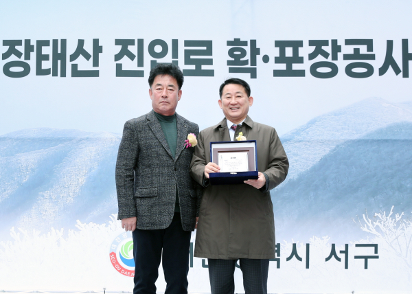 28일 열린 장태산 진입로 확·포장공사 준공식에서 감사패를 받은 서철모 구청장