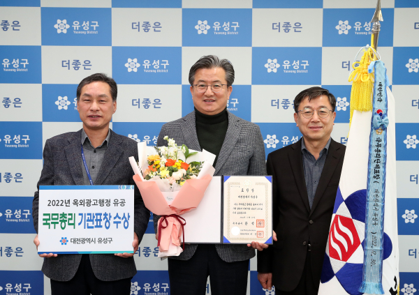 유성구가 2022년 옥외광고행정 유공기관으로 선정되어 국무총리 표창을 받은 가운데, 정용래 유성구청장(가운데)과 직원들이 기념촬영