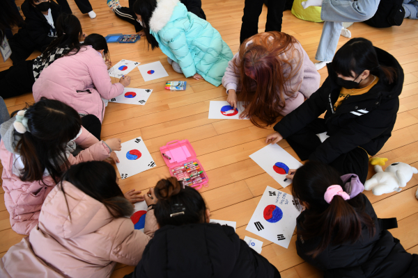 백석쿰캠프에 참여한 어린이들이 태극기를 그리고 그 안에 자신의 소망을 적고 있다.