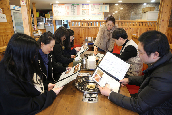지난 6일 오후 대전 서구 도안동에 있는 음식점 일미닭갈비파전에서 중국인 유학생 등이 외국어 메뉴판에 중국어로 적힌 메뉴설명을 보고 있다.
