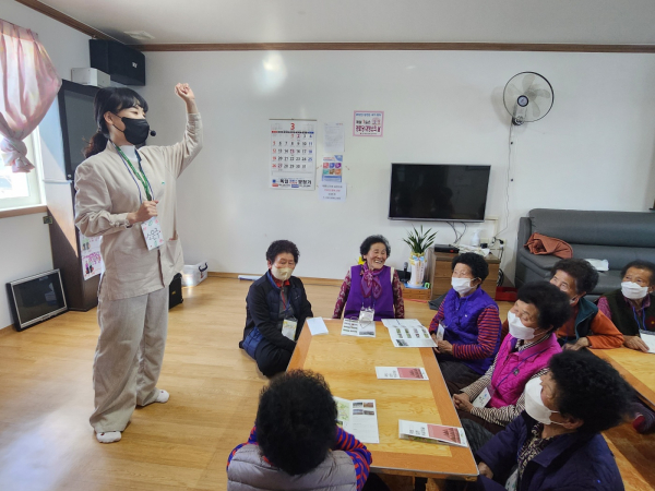 산림치유지도사가 치매보듬마을 어르신에게 항노화 산림치유에 대해 설명하는 모습