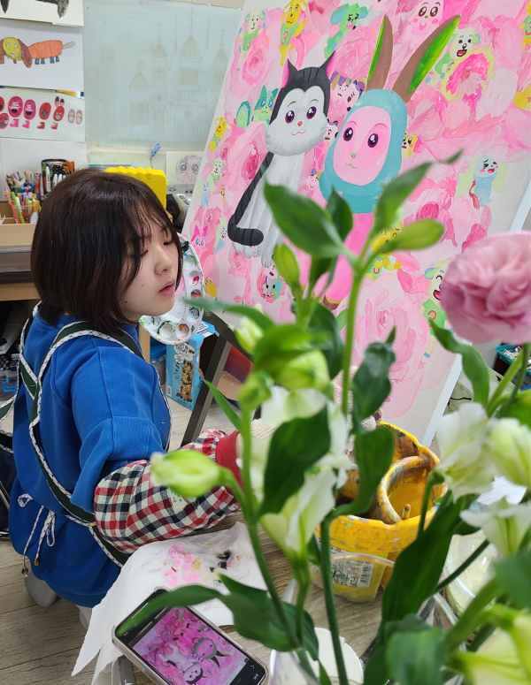 김지우씨가 작품을 그리고 있다.