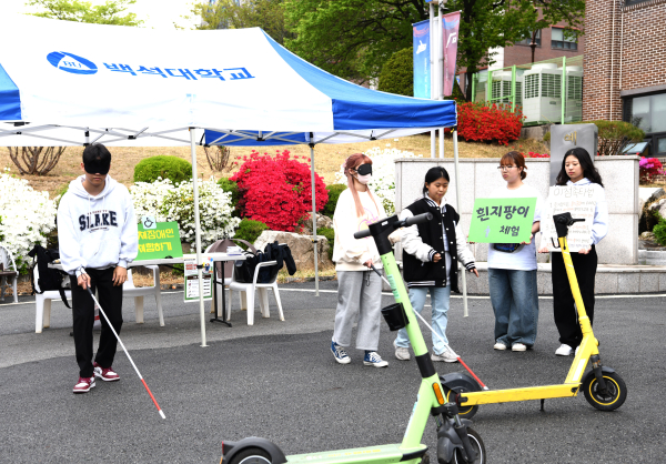 특수교육과가 진행한 ‘장애차별 철폐의 날 체험 프로그램’ 행사에서 재학생들이 ‘개인형 이동장치’를 장애물로 연출한 상황에서 흰 지팡이 체험을 하고 있다.