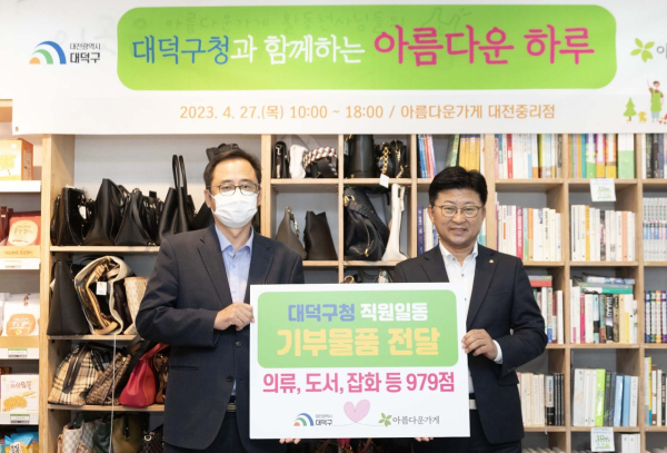 (사진 왼쪽부터) 아름다운가게 대전중리점 운영위원장 이종준, 최충규 대덕구청장이 전달식을 진행하고 기념 촬영