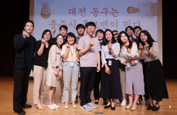 ‘충주시 홍보맨’ 김선태 주무관이 동구청 직원들에게 둘러싸여 시그니처 포즈를 취하고 있다.