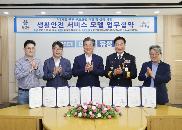 지난 26일 유성구가 유성경찰서 및 3개 기업과 컨소시엄을 구성하고 업무협약을 체결한 가운데, 정용래 유성구청장(가운데)과 참석자들이 기념촬영