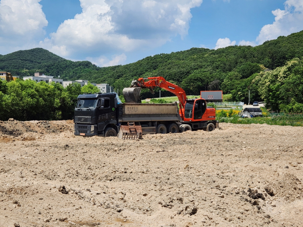 비포장비료를 부적정 살포한 비료 제조사업장이 지난 14일 장군면 금암리 소재 농경지에서 중장비를 동원해 문제가 된 비료를 걷어내고 있다