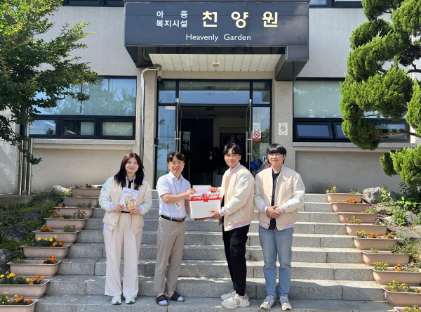 아동복지시설 천양원 현관에서 목원대 사범대학 학생회 임원들이 천양원 관계자에게 기부금과 간식을 전달하며 기념촬영