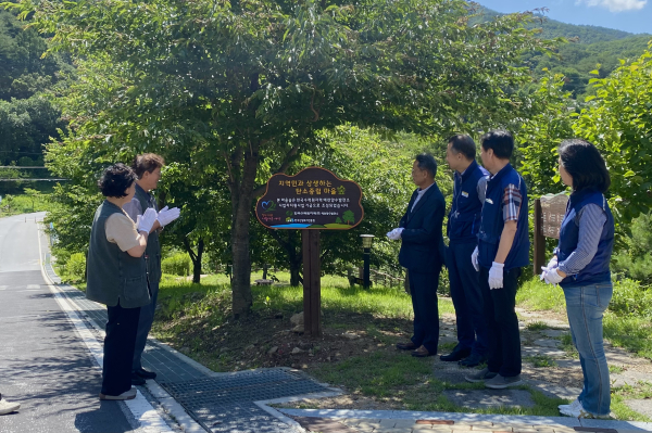27일 경북 예천군 효자면 문필지구에서 탄소중립 마을숲 조성을 기념하여 국립산림치유원 및 예천양수발전소 임직원들이 준공기념 현판 제막식을 하고 있다.