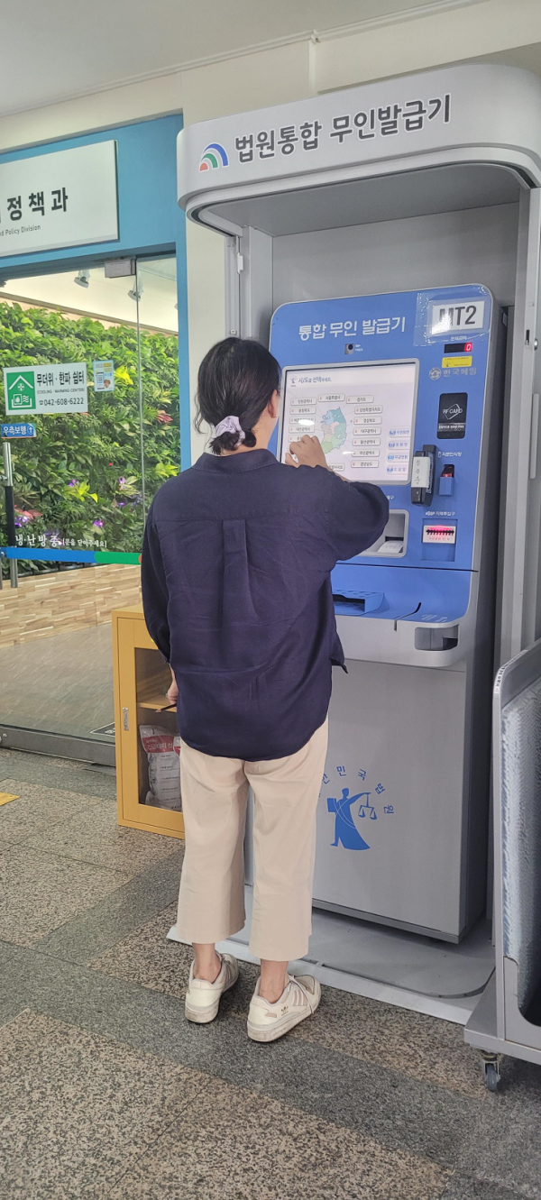 구청 1층 로비에 설치한 법원전용 무인민원발급기를 민원인이 이용하고 있는 모습