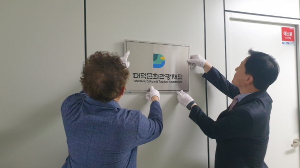 (사진 왼쪽부터) 정인 대덕구 복지문화국장과 임전배 대덕문화관광재단 상임이사가 지난 21일 대덕문화관광재단 현판을 붙이고 있다.