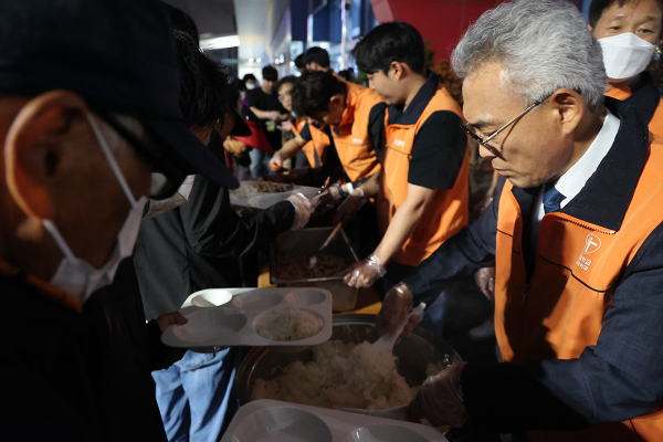 지난 13일 오후 대전역 광장에 차려진 거리 급식소에서 이희학 목원대 총장(오른쪽) 등 구성원들이 배식봉사를 하고 있다.