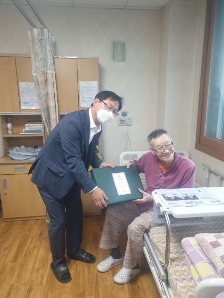 강만희 대전지방보훈청장(좌)이 보훈요양원에 입소중인 국가유공자(우)에게 위문품을 전달하고 있다