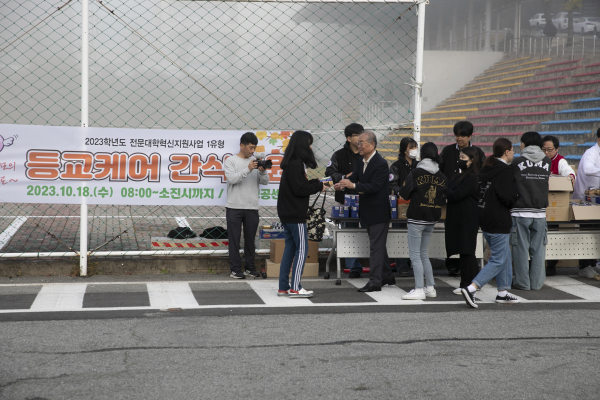 18일 한국영상대학교 유재원 총장이 등교케어 행사에서 학생들에게 아침식사를 건네주고 있다.