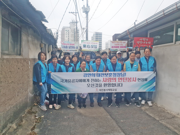 강만희 대전지방보훈청장과 대전봉사체험교실 봉사자분들이 연탄 봉사 후 기념 촬영하고 있다.