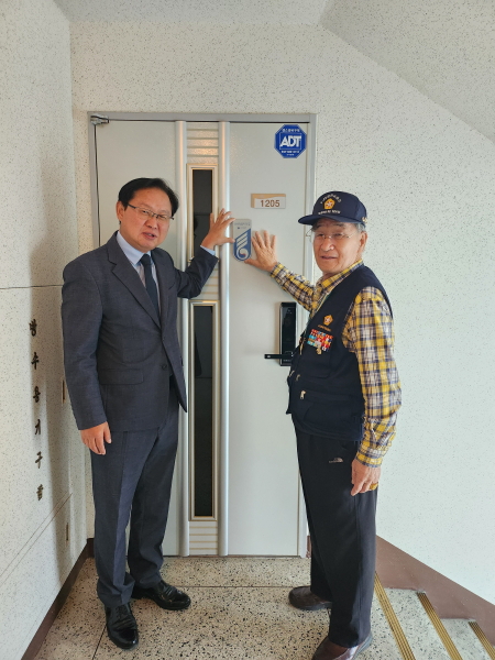 강만희 대전지방보훈청장(좌)과 6‧25참전유공자(우)가 국가유공자의 집 명패를 부착하고 있다