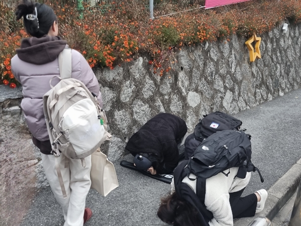 수험생 친구와 함께 시험장을 찾아 큰절하는 학생들