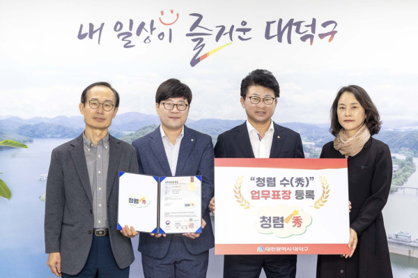 최충규 대덕구청장(사진 왼쪽 세 번째)과 대덕구 직원들이 2023년 10월 16일 지자체 최초로 ‘청렴 수(秀)’ 디자인 업무표장을 등록한 후 등록증을 들고 기념 촬영