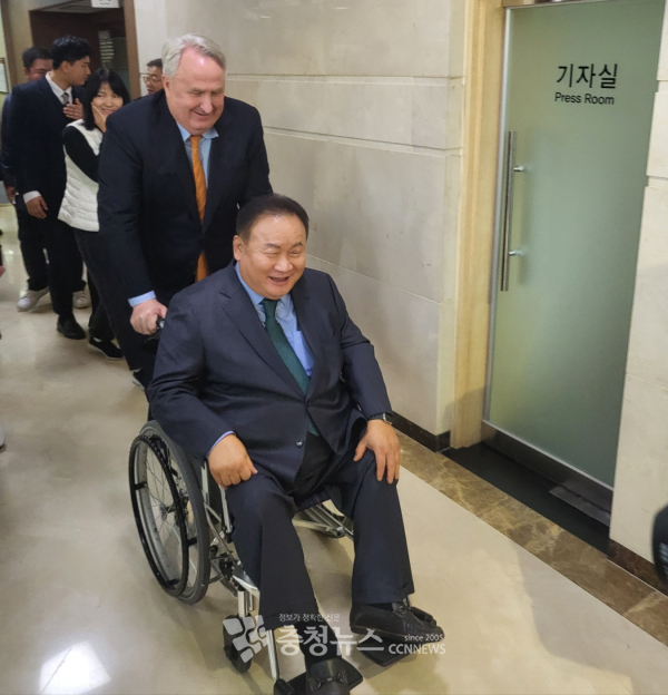 국민의힘 인요한 혁신위원장이 더불어민주당 이상민 의원 휠체어를 밀어주고 있다.