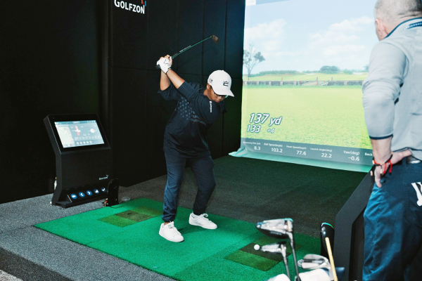 2024 PGA쇼에서 박람회 관람객이 골프존 시뮬레이터 제품을 체험하고 있다.