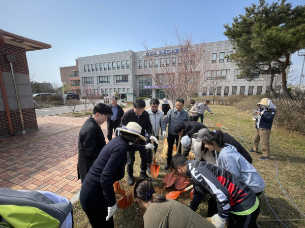 관계자들과 난민 가족과 함께 무궁화나무를 심고 있다.