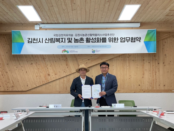 지난 11일 박한진(우측) 국립김천치유의숲 센터장이 신현일(좌측) 김천시농촌신활력플러스사업추진단 단장과 업무협약을 체결한 뒤 기념촬영을 하고 있다.