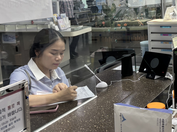 한 외국인 민원인이 민원통역서비스(오른쪽 단말기)를 통해 민원 서류를 작성하고 있다.