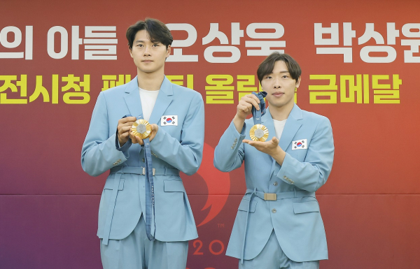 오상욱 선수와 박상원 선수가 파리 올림픽 금메달을 보여주고 있다.