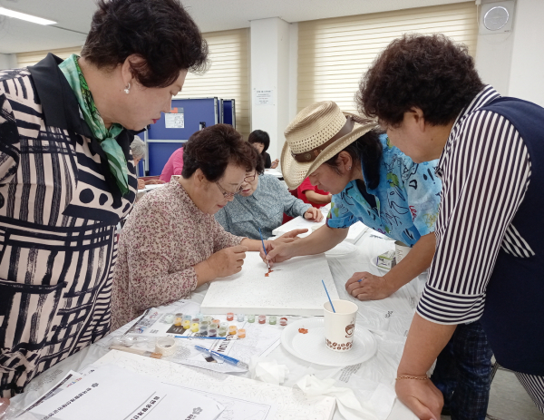 7월 19일 남면 복지회관에서 열린 생활개선 기술전달 연찬회에서 참여자들이 ‘해바라기 그림 그리기’를 진행하는 모습.